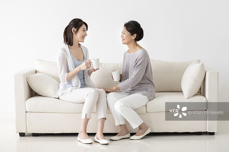开心的母女俩坐在沙发上聊天图片素材