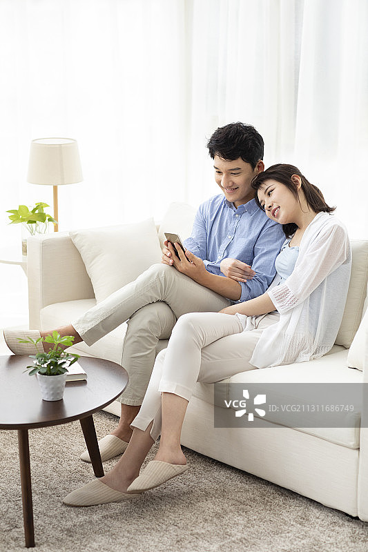 开心的年轻情侣玩手机图片素材