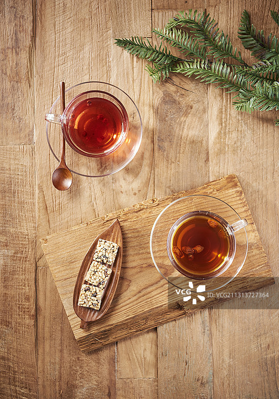 两杯传统茶和甜糯米泡芙放在木板和地板上图片素材