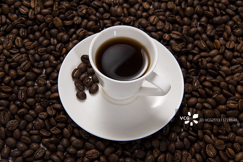 一杯放在烘培咖啡豆上的咖啡图片素材