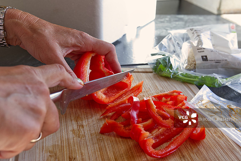 在厨房里切红辣椒的女人图片素材