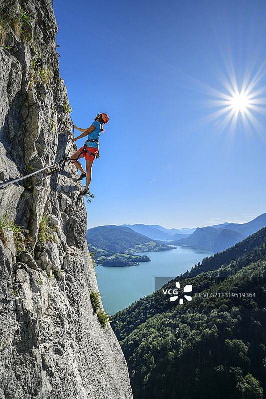 奥地利萨尔茨堡萨尔茨卡默古特，一名女子通过德拉肯旺德的费拉塔攀登，背景是蒙西图片素材