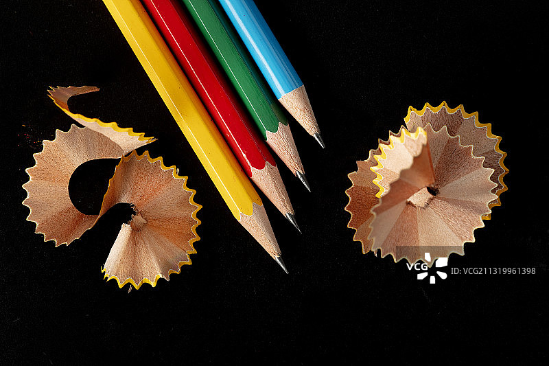 彩虹铅笔和铅笔刨花在纯黑色的背景图片素材