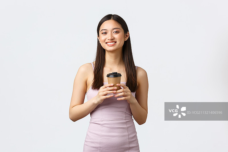 微笑的年轻女子的肖像在白色的背景下拿着牛奶在饮用玻璃图片素材