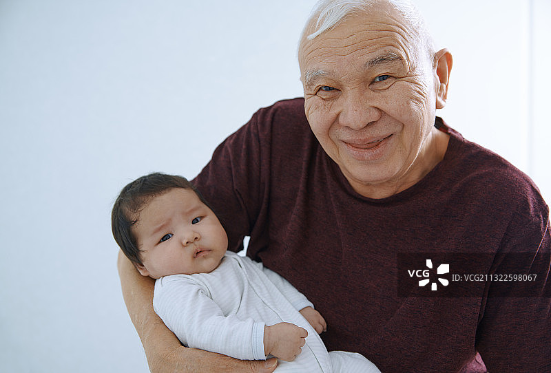 一位老人抱着刚出生的孙子图片素材