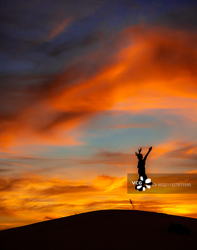 巴西，日落时，剪影女子跳向天空图片素材