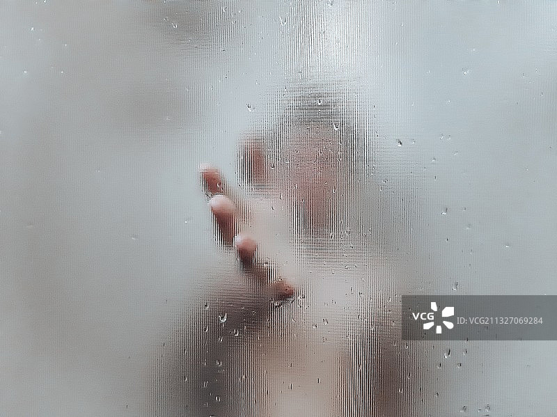 透过湿漉漉、雾蒙蒙的玻璃，特写扭曲的双手图片素材