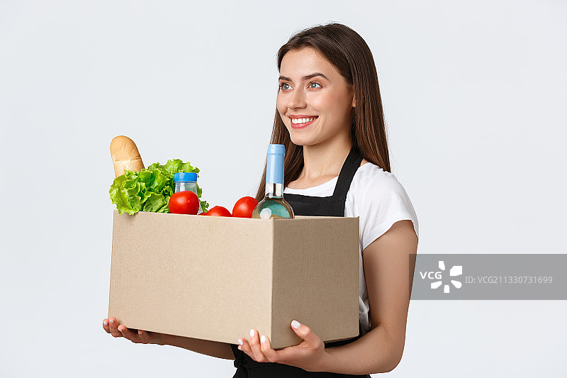 微笑的年轻女子的肖像拿着蔬菜，而站在白色的背景图片素材