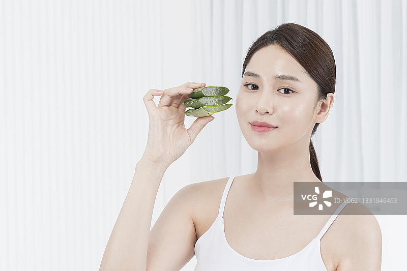 美丽的亚洲韩国模特抱着芦荟，皮肤美容的概念图片素材