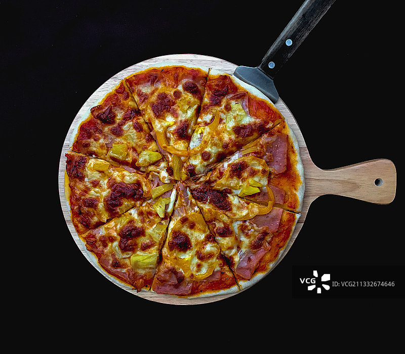 上图为黑色背景下的披萨，泰国Warin Chamrap图片素材