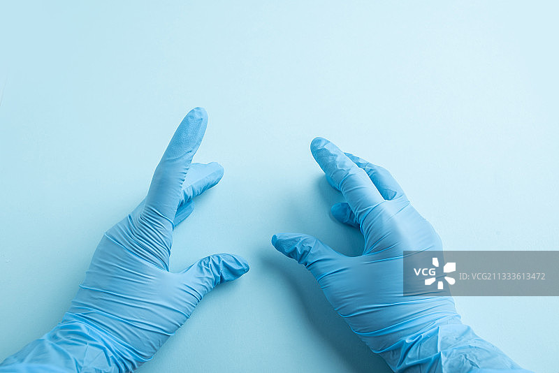 双手戴着蓝色一次性手套的医护人员图片素材