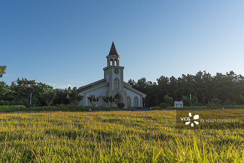 威海九龙湾公园的教堂，傍晚金色的阳光洒满了草地图片素材