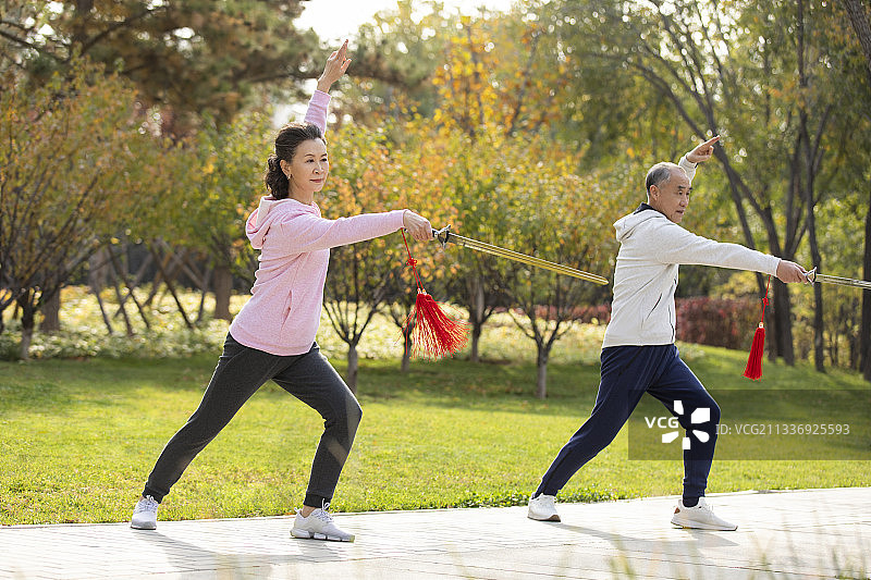 快乐的老年人在公园舞剑图片素材