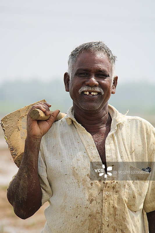 印度泰米尔纳德邦，肩上扛着工具的男子在做苦工图片素材