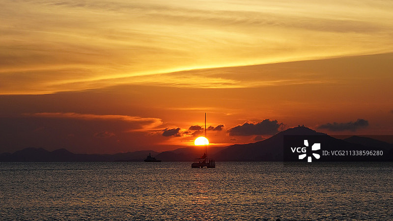 海南岛三亚湾海边黄昏日落帆船图片素材