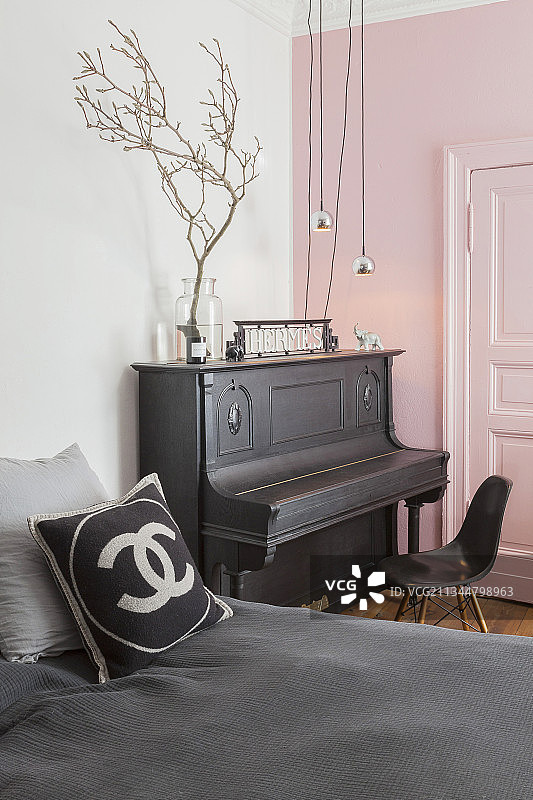 钢琴靠在粉红色的墙壁和嵌板门的卧室图片素材
