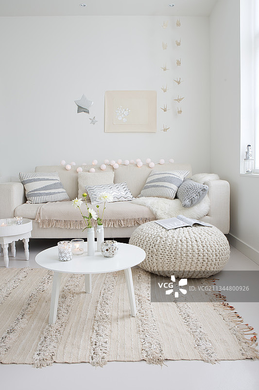 沙发、靠垫、桌子和坐垫摆放在装饰得很有节日气氛的白色客厅里图片素材