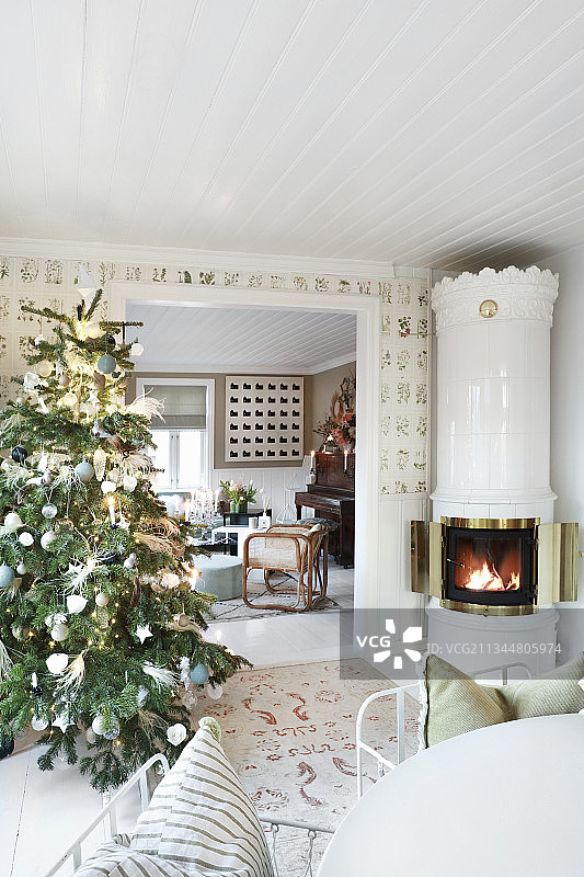乡村客厅里装饰的圣诞树和瑞典瓷砖火炉图片素材