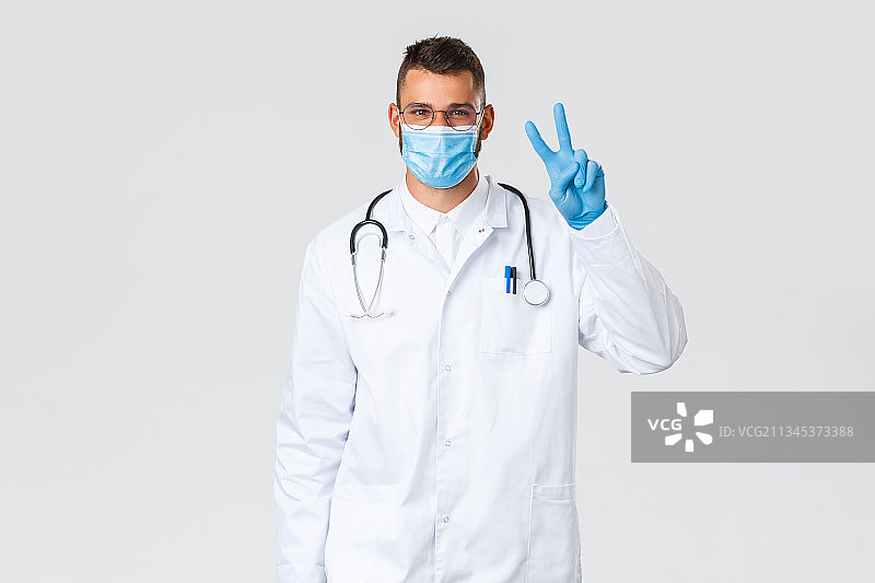 医生的肖像，戴着外科口罩，站在白色背景图片素材