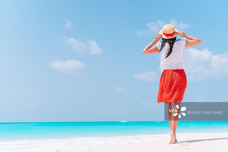 一个女人站在沙滩上，在天空的衬托下图片素材