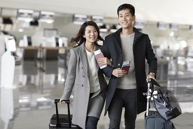 快乐的年轻夫妇在机场拿着机票和护照图片素材