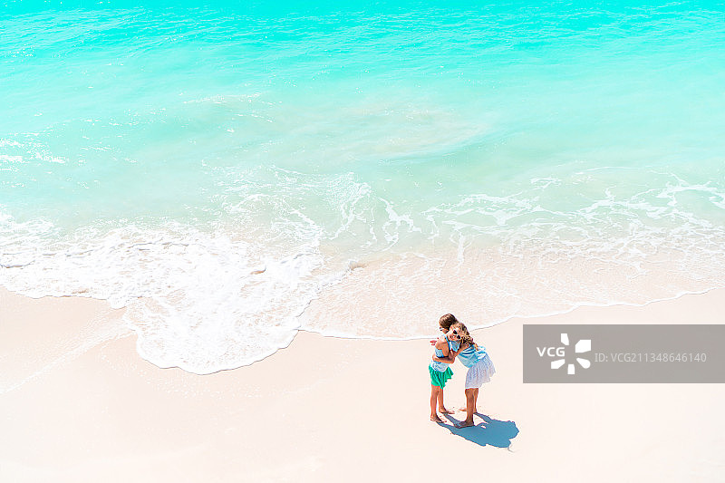 一对夫妇在海滩上散步的鸟瞰图图片素材