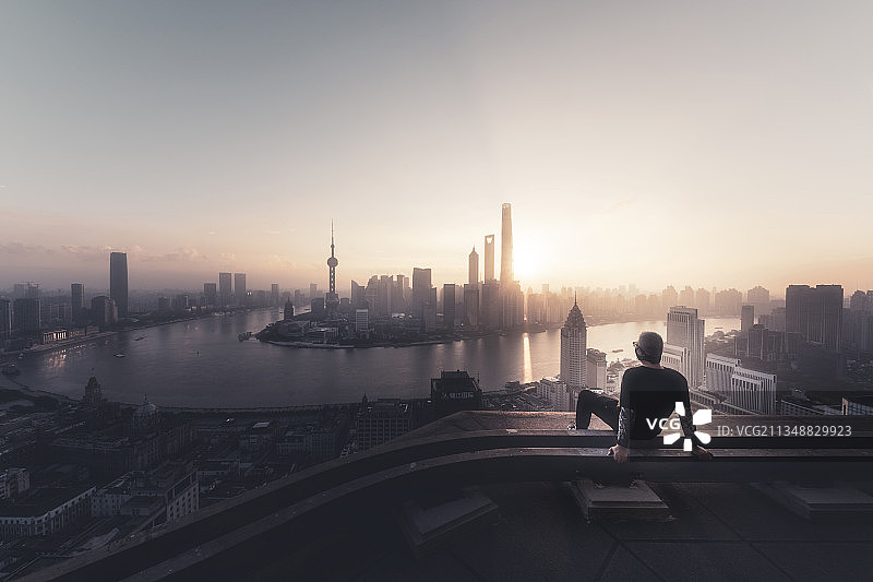 一个再上海城市楼顶看天际线日出的男人图片素材