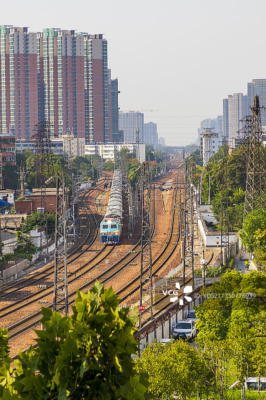 河南省郑州市城区京广铁路火车、高铁与城市夏天户外风光图片素材