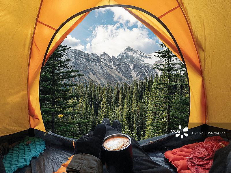 旅行者在加拿大国家公园的帐篷里休息和拿着咖啡图片素材