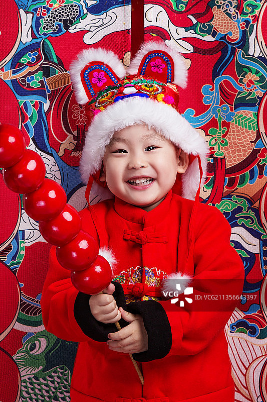 戴着虎头帽子的小男孩欢度中国年图片素材