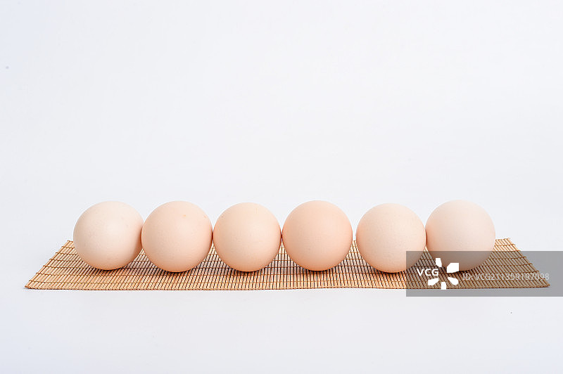 鸡蛋在竹席餐垫上图片素材