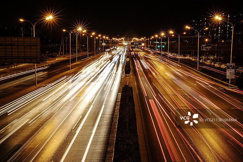 城市交通，在夜间高速公路上的灯光小径的高角度视图图片素材