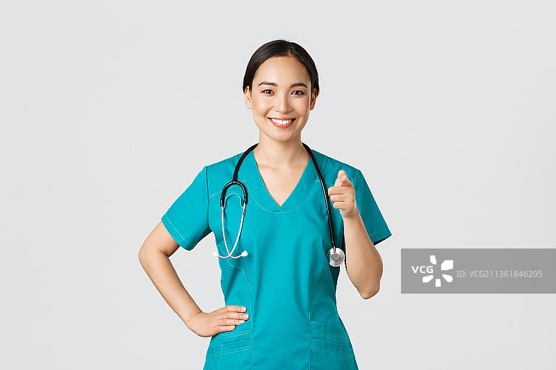 Covid-19、医护人员、大流行概念自信的微笑，微笑的女医生的肖像，站在白色背景下图片素材