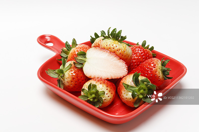 白色背景盘子里的草莓，草莓切面图片素材