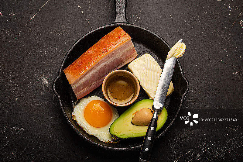 生酮饮食的食物在黑色背景的铸铁锅中图片素材