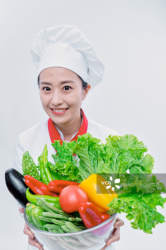 青年女性厨师端着蔬菜图片素材