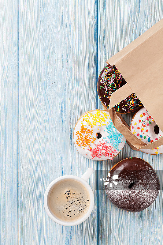 纸袋和咖啡杯里的五彩甜甜圈图片素材