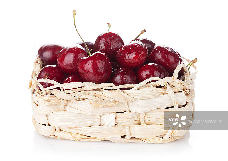 成熟的樱桃篮，樱桃在柳条篮在白色背景的特写图片素材