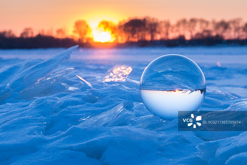 冬天日落时分冰河上的水晶球图片素材