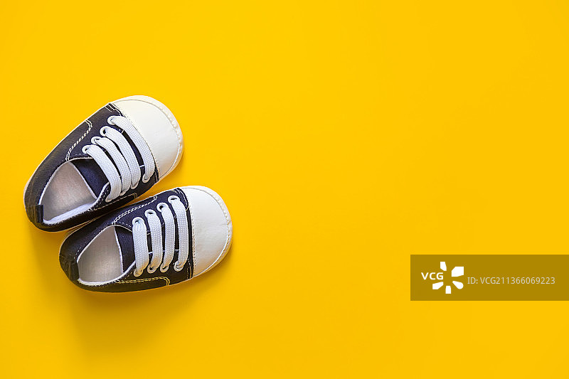 新生儿鞋黄色背景选择性聚焦图片素材