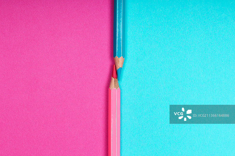 两支彩色铅笔分别在两张不同颜色的纸上图片素材