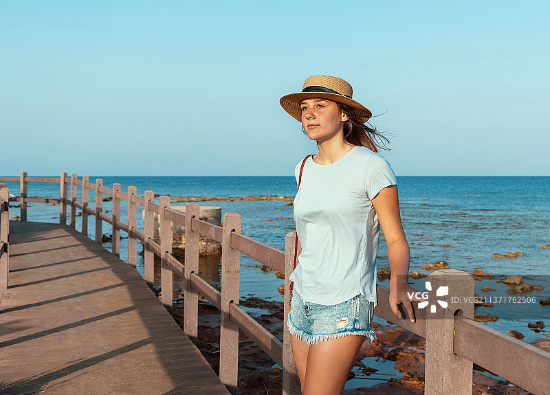 少女站在海边的木桥上图片素材