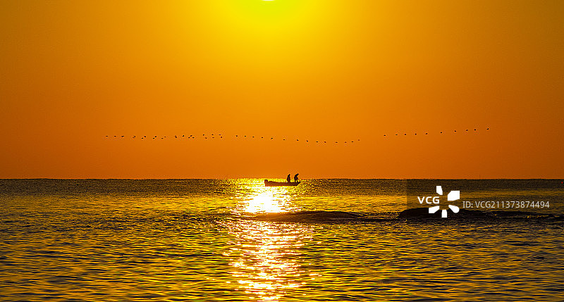 日出海边的捕鱼人图片素材