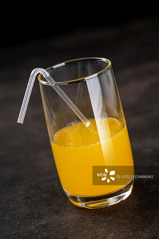 橙汁与橙子摆放在黑色背景上特写图片素材
