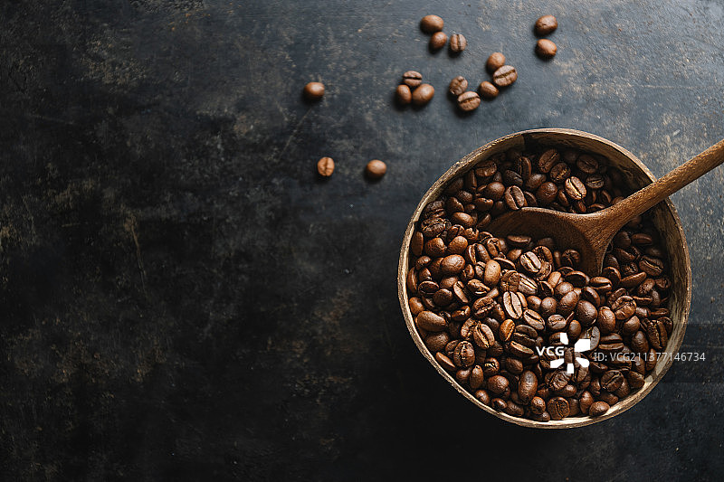 咖啡豆在黑暗的背景，高角度的视图咖啡豆在碗上的桌子图片素材