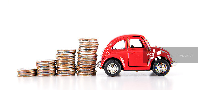 白背景上的红色小汽车和一排美元硬币图片素材