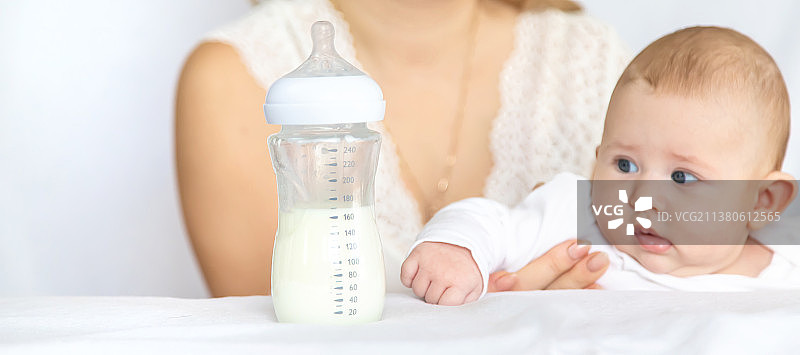 妈妈用奶瓶喂宝宝选择性聚焦图片素材