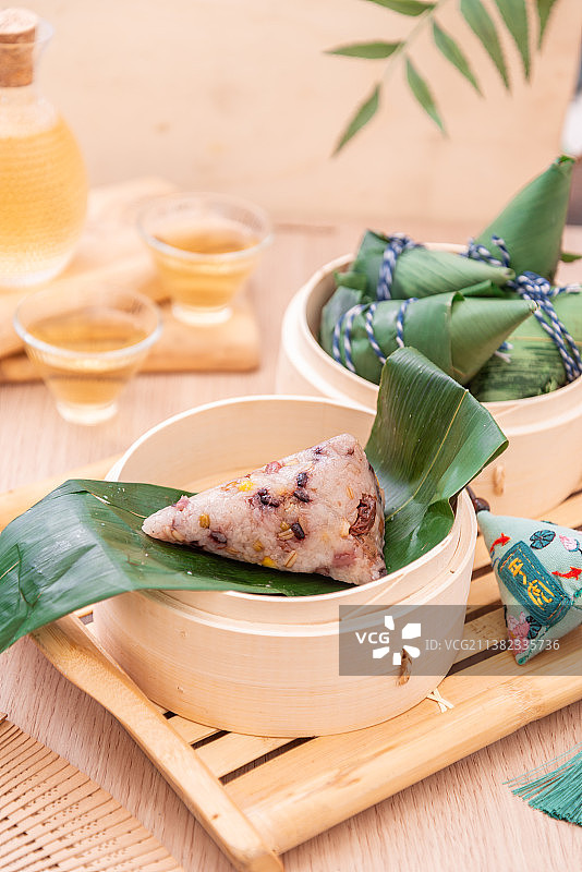 夏季端午节木桌上竹制蒸笼里的八宝粽子图片素材