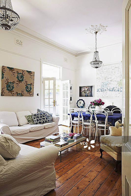 沙发搭配白色宽松套，极简风格的茶几，质朴的木地板，用餐区白色Thonet椅子图片素材