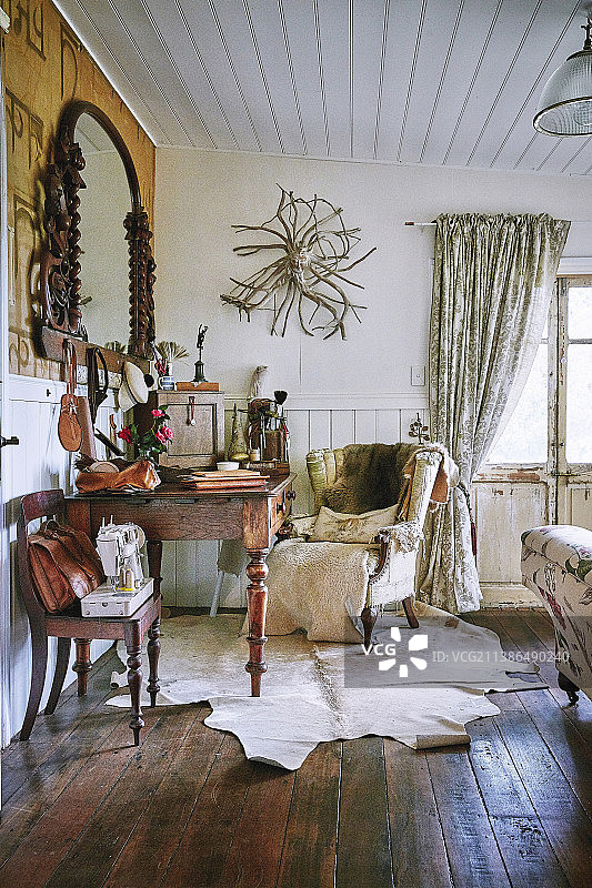 复古的动物毛皮地毯上的Anitk桌和翼椅图片素材